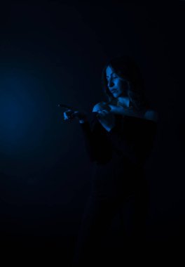 Mavi bir arka planda duran genç bir kadının gizemli bir siluetinin portresi.