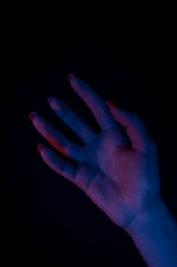 Karanlık arka planda kadın eli silueti, yakın plan.,