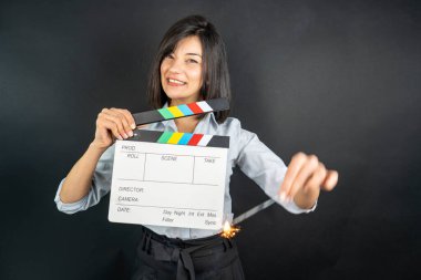 woman holding black clapperboard or movie slate clipart