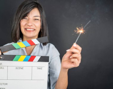 woman holding black clapperboard or movie slate clipart