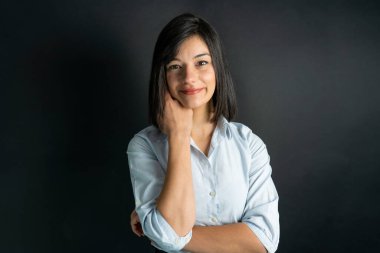 Mavi gömlek giyen gülümseyen iş kadınının izole edilmiş bir stüdyo resmi..