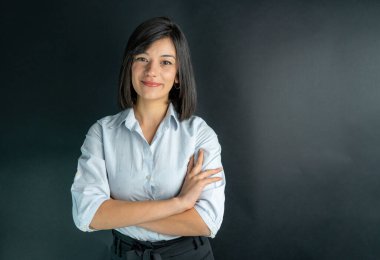 Mavi gömlek giyen gülümseyen iş kadınının izole edilmiş bir stüdyo resmi..