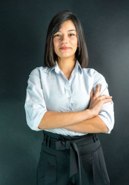 Mavi gömlek giyen gülümseyen iş kadınının izole edilmiş bir stüdyo resmi..