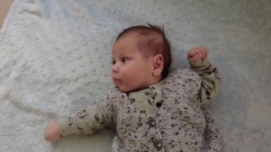 Küçük bir bebeğin portresi. Küçük bebek yatakta mutlu yatıyor.