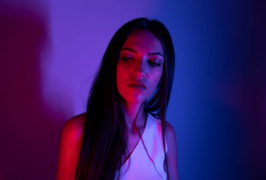 Renkli parlak neon ışıklarıyla stüdyoda poz veren yüksek model kadın. Parlak makyajlı güzel bir kadının portresi. Sanat tasarımı canlı biçimi