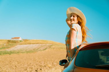 Arabayla seyahat eden iki kız arkadaş. Araba camından dışarı bakan mutlu kadın.