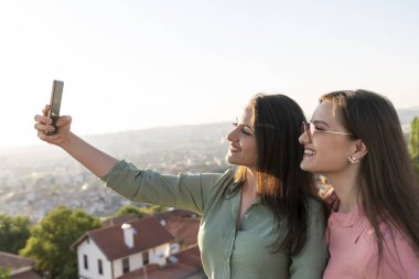 Şehirde selfie çeken iki genç kadın.