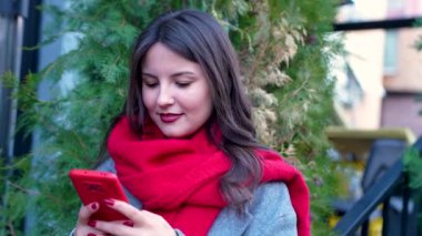  Bir iş merkezinin önünde akıllı telefonla çalışan genç bir iş kadını.