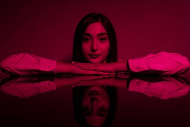 Renkli parlak neon ışıklarıyla stüdyoda poz veren yüksek model kadın. Parlak makyajlı güzel bir kadının portresi. Sanat tasarımı canlı biçimi