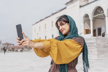 Genç Müslüman kadın seyahat ederken selfie çekiyor.