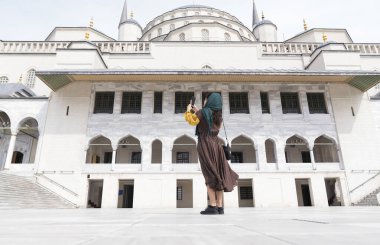 Young Muslim woman taking selfie while traveling clipart