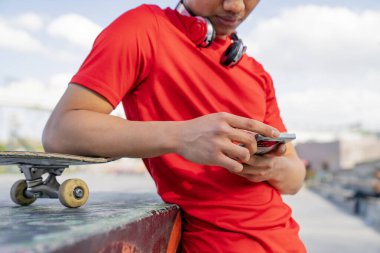 Rahatlama ve rahatlama kavramı, adam telefonuna bakmak için kaykay yapmaya ara veriyor.