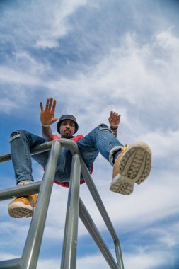 Genç bir adam metal korkuluklarda poz veriyor.