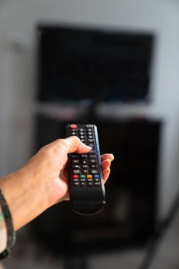 Bir TV kumandası tutan kişi