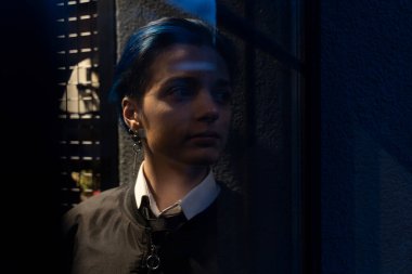 Genç düşünceli kadın gece manzarasına bakıyor.