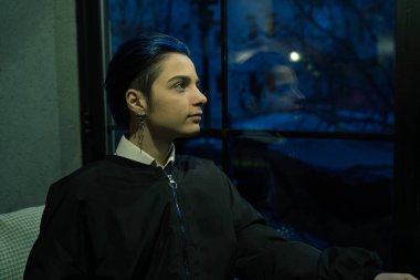 Genç düşünceli kadın gece manzarasına bakıyor.