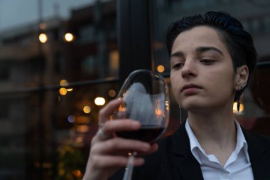 Bir bardak şarap tutan genç kadın