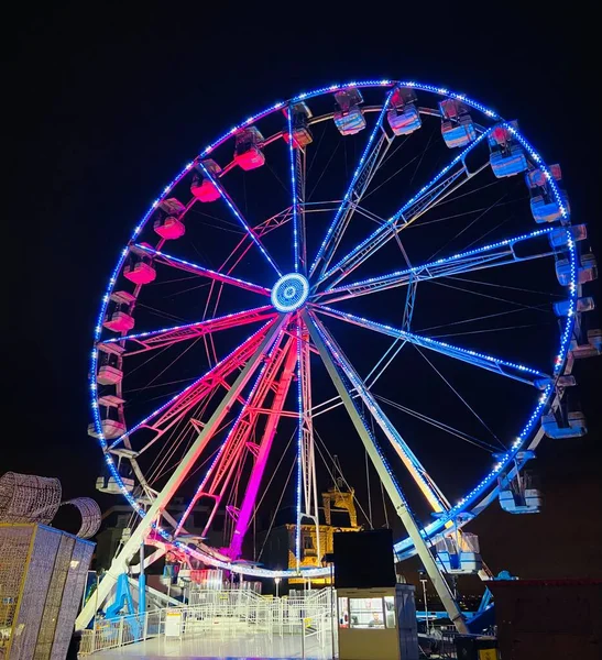 ferris wheel carousel on night sky background. amusement park with blue hour in the city.
