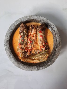 Genel olarak, halibut patlıcanının kendisi hindistan cevizi sütü, arpacık soğanı, sarımsak, kencur, arnavut biberi kullanılarak pişirilir. Sonra acılı sosun üstüne.