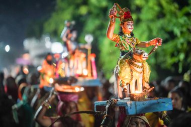 Hindistan 'daki Diwali Festivali' nde bir kadın ve tanrıların heykelini taşıyan bir kadının başındaki tanrısal heykel..