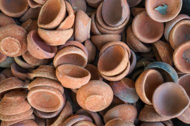 Çamurdan ya da çamurdan yapılmış Hindistan ya da diya 'nın yakın çekimi, pazarda satılmak üzere bir küvette tutulan kil ya da çamurdan lamba, diwali, deep awali, Hindistan festivali, yağ fenerleri