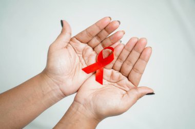 Dünya HIV Yardım Günü 2022-2023, Dünya 'nın beyaz arka plan konsepti HIV günü için kırmızı yardım şeridi tutan eller