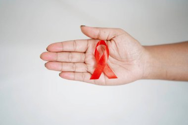 Dünya HIV Yardım Günü, Sağlık Konsepti, HIV AIDS Farkındalığı 'nı temsil eden kırmızı kurdele tutan bir kadın