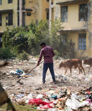 Aralık 2022, Raipur, Hindistan: Çöpü süpürge ve polihtan ile süpüren adam büyük çöp alanı, kirlenmiş bölgeyi temizleyen adam, kirlilik kontrol günü, kirlilik konsepti