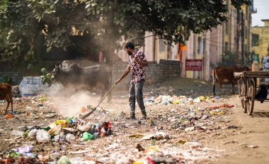 Aralık 2022, Raipur, Hindistan: Çöpü süpürge ve polihtan ile süpüren adam büyük çöp alanı, kirlenmiş bölgeyi temizleyen adam, kirlilik kontrol günü, kirlilik konsepti