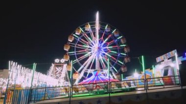 Renkli ışıklarla dönen dev dönme dolap manzarası, Hint karnavalı eğlence parkı geceleri