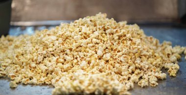 Dağıtılmış tuzlanmış patlamış mısır, doku arka planı. Film ve sinema konsepti, patlamış mısır makinesinde patlamış mısır satışı, patlamış mısır kızartma makinesinde patlamış mısır kızartma makinesinde patlamış mısır.