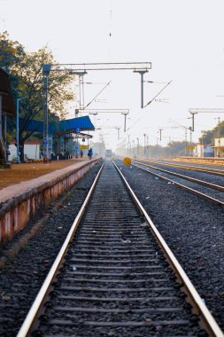 railway platform or station with track, cable line goes above the rail line to pass electricity, Metal railway track in india, metal track for train in india, travel and transportation concept.