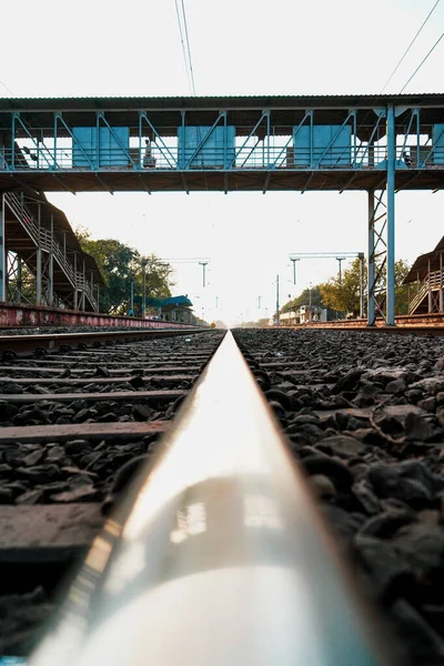 Low angle shot railway track with RAILWAY STEEL FOOT OVER BRIDGE, shallow depth of field, Metal railway track in india, train tracks, metal track for train in india, travel and transportation concept.