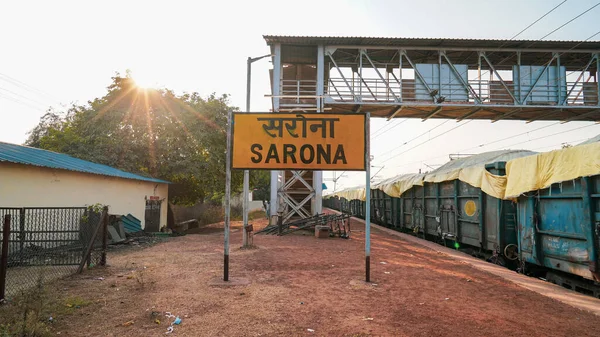 indian Railway station, Sarona Raipur railway junction in india, Yellow sign board in railway station and foot over bridge in background to cross over to opposite side of train tracks, stock photo