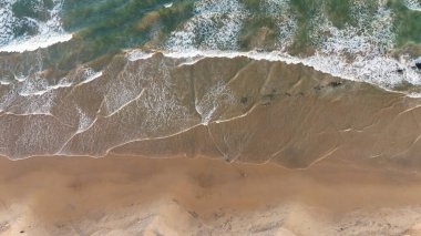 Berrak bir günde sakin okyanus dalgalarıyla geniş kumlu sahil, yumuşak sörf ve açık gökyüzü ile huzurlu sahil manzarası, yumuşak dalgalar ve temiz kumla doğal deniz manzarası, mavi sularla dolu sakin sahil manzarası ve boş kıyı şeridi, vizag konumu.