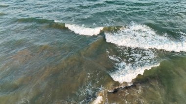 Berrak bir günde sakin okyanus dalgalarıyla geniş kumlu sahil, yumuşak sörf ve açık gökyüzü ile huzurlu sahil manzarası, yumuşak dalgalar ve temiz kumla doğal deniz manzarası, mavi sularla dolu sakin sahil manzarası ve boş kıyı şeridi, vizag konumu.