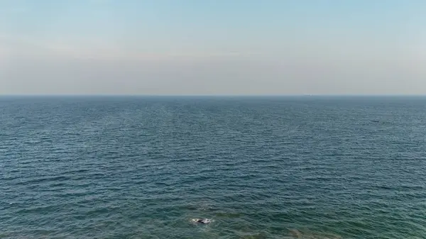 Berrak bir gökyüzü altında sonsuz mavi su ile okyanus manzarası, sakin dalgalar ve açık ufuk içeren huzurlu deniz manzarası, yumuşak dalgalar ve engin açık su ile huzurlu deniz manzarası, doğal mavi tonlu minimalist okyanus manzarası ve açık hava.