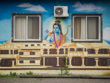 Lord Ram ve Ram Mandir 'in renkli duvar sanatı, Lord Rama' nın duvar resmi, bina pencereleri arasında resim, dış duvarda Ram Mandir 'in sanatsal tasviri, şehir cephesinde Hindu dini resim.