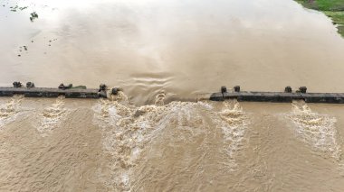 Çalkantılı kahverengi su akıntısıyla dolu baraj manzarası muson mevsiminde güçlü su akıntılarıyla dolu baraj akıntısı barajın taşması baraj taşması şiddetli yağış sonrasında çamurlu su salınımı, baraj kapılarından akan yüksek su basıncı.