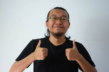 Siyah tişörtlü, uzun saçlı, gülümseyen ve kameraya bakmaktan vazgeçen yetişkin bir Asyalı.