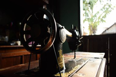 Tuban, Endonezya - 7 Eylül 2023: Ahşap masanın üzerinde antik bir Kelebek Dikiş Makinesi. Eski, Eski, Retro Dikiş Makinesi