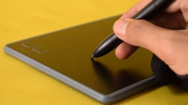 Dijital tablete kurşun kalemle el çizimi yakın plan. Grafik tableti üzerinde çalışan profesyonel.