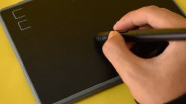 Dijital tablete kurşun kalemle el çizimi yakın plan. Grafik tableti üzerinde çalışan profesyonel.