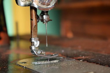 Dikiş makinesini ahşap masaya iğneyle kapatın. Antika dikiş makinesini tozla kaplayın.