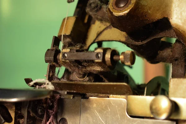 Close up an antique Overlock Sewing Machine on the wooden desk.
