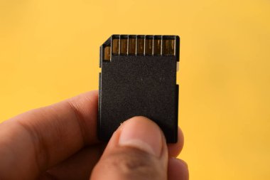DSLR ya da aynasız kamera için sarı arkaplanda SD kartı var.