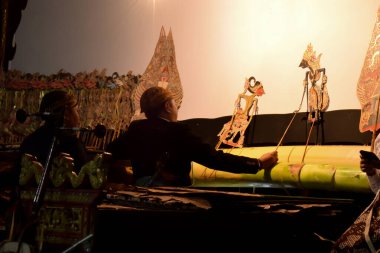 Bir adam gece vakti sahnede Wayang ya da geleneksel Cava kuklası ile gösteri yapar. Tuban, Endonezya - 22 Eylül 2023.