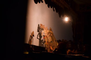 Bir adam gece vakti sahnede Wayang ya da geleneksel Cava kuklası ile gösteri yapar. Tuban, Endonezya - 22 Eylül 2023.