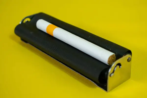 Sigara Yapmak Için Siyah Metal Silindir Sarı Arka Planda Yapımı — Stok fotoğraf