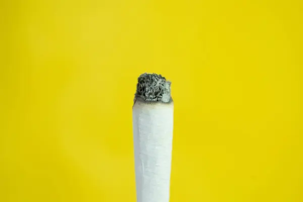 Eine Hand Hält Eine Handgemachte Zigarette Auf Gelbem Hintergrund — Stockfoto